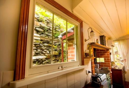 okno w kuchni z kamienną ścianą w obiekcie Spetts Cottage w mieście Walhalla