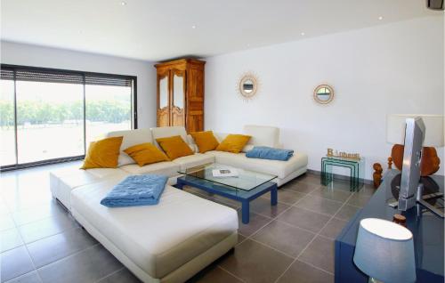 a living room with a white couch and a tv at Amazing Home In Montlimar With Outdoor Swimming Pool in Montélimar