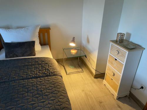 1 dormitorio con 1 cama y vestidor con lámpara en FeWo am Fusse der Landeskrone mit Sauna en Görlitz