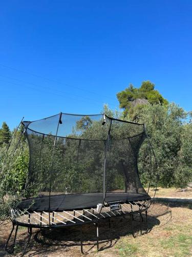 an empty swing in the middle of a park at Paralia Homes cheerful 2 bedroom with pool, unit #1 in Kriopigi