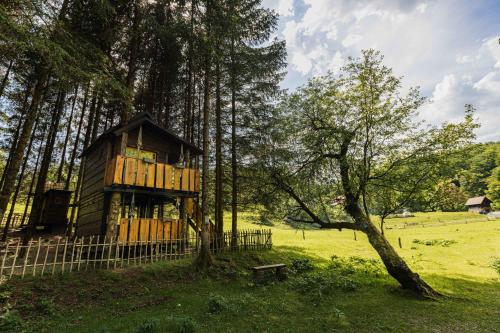 una casa sull'albero seduta in mezzo a un campo di Treehouse KUPARI Nacionalni park Risnjak a Čabar