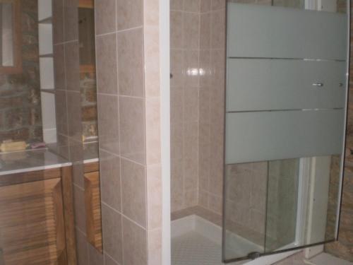 um chuveiro com uma porta de vidro na casa de banho em Maison Belz, 3 pièces, 4 personnes - FR-1-397-19 em Belz
