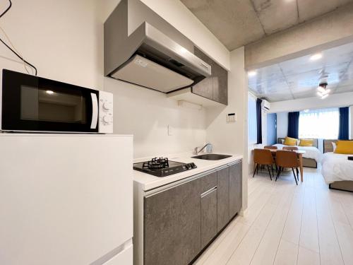 una cocina con estufa horno superior junto a la sala de estar en Wellsquareism Honancho, en Tokio