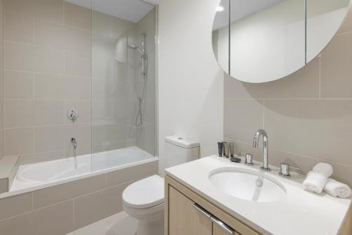 a bathroom with a sink and a toilet and a tub at Imagine Southbank in Melbourne