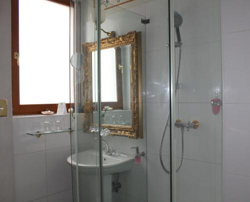 a bathroom with a shower and a sink and a mirror at Albergo City Hotel Berlin in Berlin