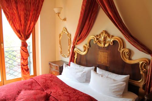 a bedroom with a large bed with a red canopy at Albergo City Hotel Berlin in Berlin