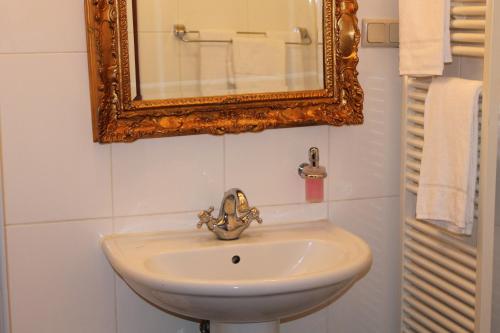 a bathroom with a sink and a mirror and towels at Albergo City Hotel Berlin in Berlin
