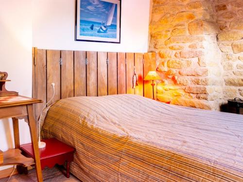 a bedroom with a bed and a stone wall at Maison Charmante à Ploemeur - Proche Plages et Campagne - 7 Couchages avec Jardin et Wifi - FR-1-349-105 in Ploemeur