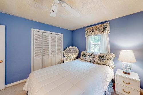 a blue bedroom with a bed and a window at Cobb House in Highlands