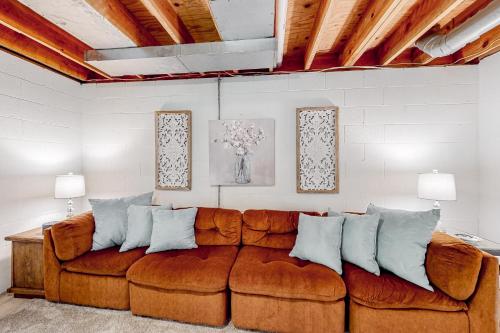a living room with a brown couch with pillows at Cobb House in Highlands