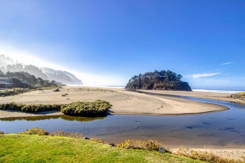 a beach with a body of water next to a beach at Proposal Rock Charmer in Neskowin
