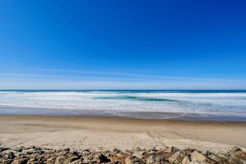 a beach with rocks and the ocean on a clear day at Proposal Rock Charmer in Neskowin