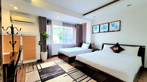 Cette chambre comprend 2 lits et une fenêtre. dans l'établissement Red Building - Hotel - Hà Nội, à Hanoï