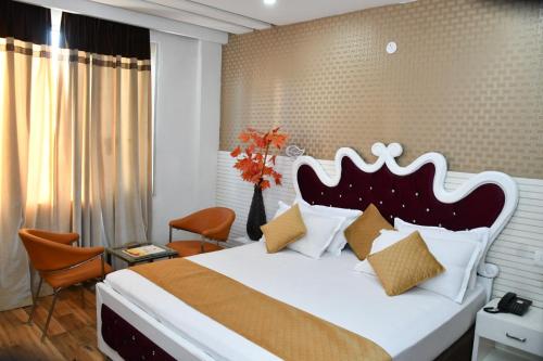 una camera da letto con un grande letto e un copriletto bianco di Hotel Royal Comfort Inn a Pinjaur