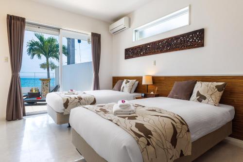 two beds in a bedroom with a view of the ocean at Coldio Marina Kin in Kin
