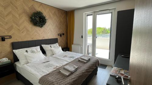 a bedroom with a bed with two towels on it at Top Design Apartment in Fonyód