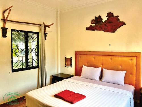 a bedroom with a bed with a red towel on it at Garden Village Guesthouse & Pool Bar in Siem Reap