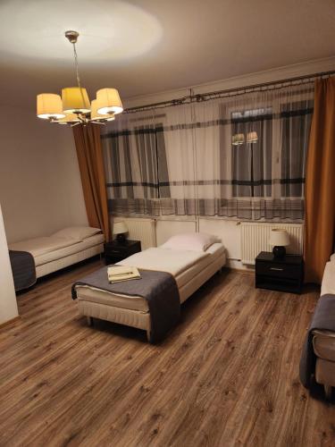 1 dormitorio con 1 cama grande y suelo de madera en Zajazd FENIKS en Lubaczów