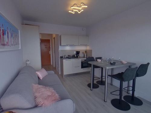 un salon avec un canapé et une table dans l'établissement Studio rénové avec balcon vue mer, WIFI, proche plage et commerces - 2 pers - FR-1-349-148, à Ploemeur