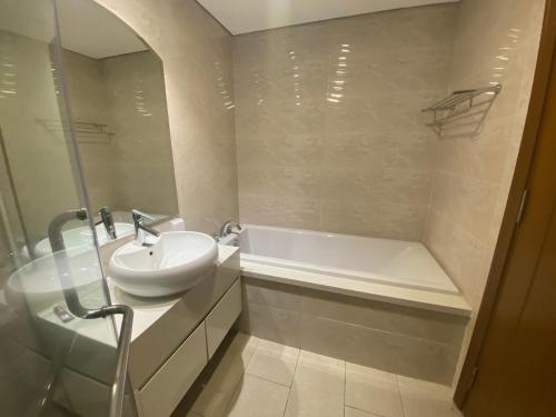a white bathroom with a sink and a bath tub at Jessie Saigon Apartment - Vinhome Central Park in Ho Chi Minh City
