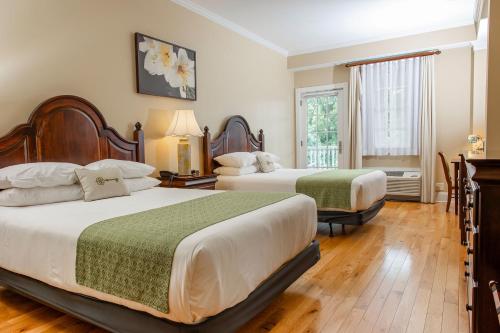 フェアボーンにあるMills Park Hotelのベッド2台と窓が備わるホテルルームです。