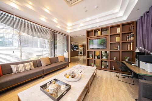 a living room with a couch and a table at Benikea Hotel Bizinn in Wonju