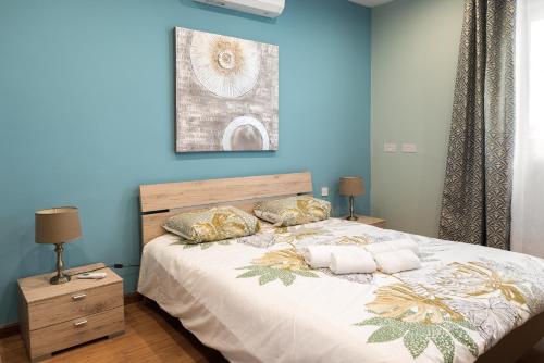 a blue bedroom with a large bed with two pillows at Entire Luxury Sliema Townhouse Steps from Beach in Sliema
