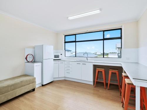 a kitchen with white appliances and a large window at Blue Door Retreat in Edithburgh