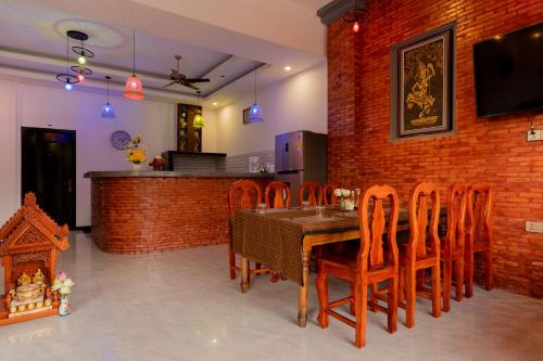 a dining room with a table and wooden chairs at Angkor Rithy Residence team in Siem Reap