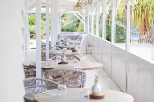 une rangée de tables et de chaises dans un restaurant dans l'établissement Opoa Beach Hotel, à Opoa