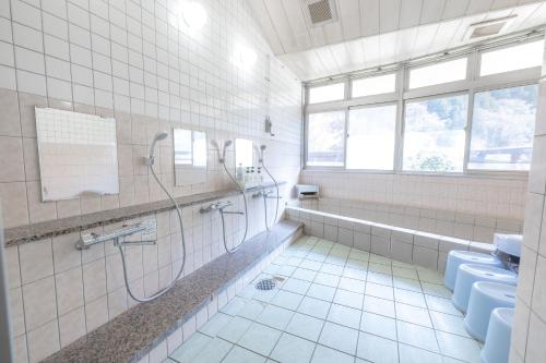 a bathroom with a shower and a toilet and a sink at リバーサイドひの in Hino