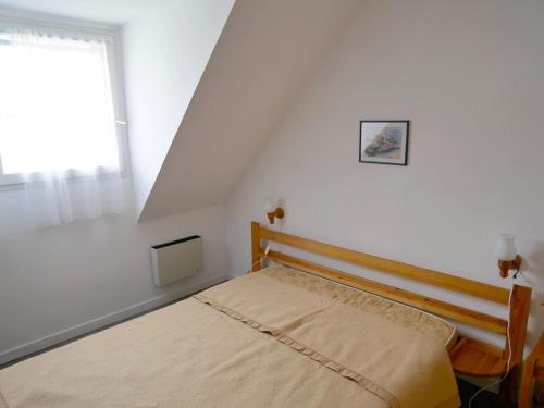 un lit dans une chambre blanche avec une fenêtre dans l'établissement Maison cosy pour 4 pers., à 250 m de la plage St-Jacques, Sarzeau - FR-1-639-31, à Sarzeau