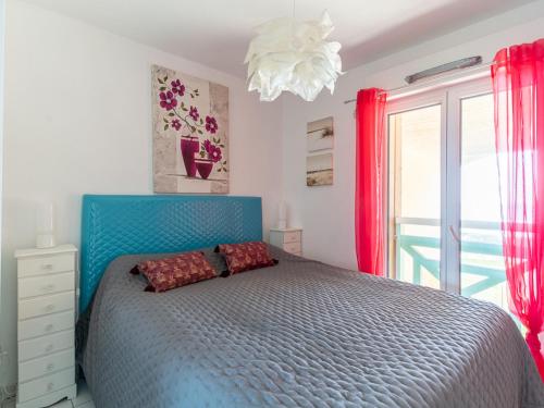 une chambre avec un lit bleu et une fenêtre dans l'établissement Mimizan Plage: Appt pour 4 avec Parking et Accès Direct à la Mer - FR-1-50-89, à Mimizan