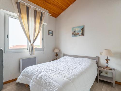 une chambre avec un lit blanc et une fenêtre dans l'établissement Mimizan Plage: Appartement T2 Mezzanine 2 étoiles, 4 pers, vue océan, parking inclus - FR-1-50-86, à Mimizan