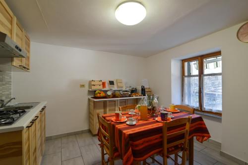 a kitchen with a table with a table cloth on it at Bed & Breakfast Ai Fontana in Villar Pellice