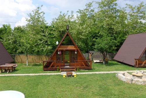 una pequeña cabaña en un patio con árboles en Casute in copac & Case A frame, en Porumbacu de Sus