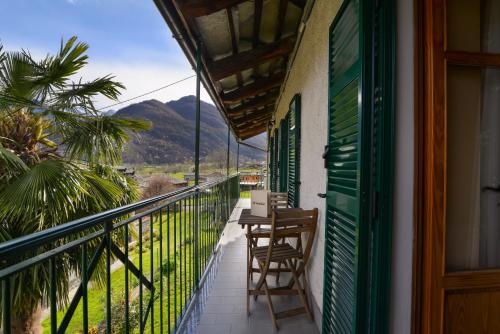 a balcony of a house with a table and chairs at Bed & Breakfast Ai Fontana in Villar Pellice