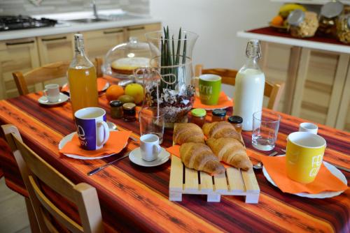 a table with croissants and bottles of milk and juice at Bed & Breakfast Ai Fontana in Villar Pellice