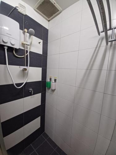 a bathroom with a shower with black and white tiles at SY Staycation - Studio in Bayan Lepas