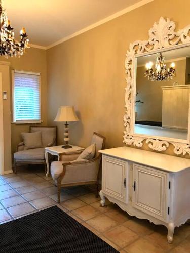 a living room with a large mirror on the wall at Olive Tree Cottage in Central Tilba