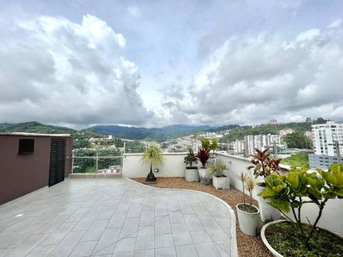 d'un balcon avec des plantes en pot et une vue sur la ville. dans l'établissement Cama Queen, Vista a las Montañas, à Manizales