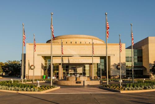 a building with american flags in front of it at Holiday Inn & Suites College Station-Aggieland by IHG in College Station