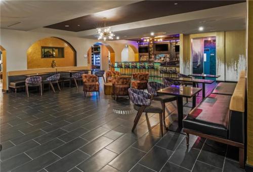 un restaurante con mesas y sillas y un bar en Hotel Indigo Spring - Woodlands Area, an IHG Hotel, en Spring