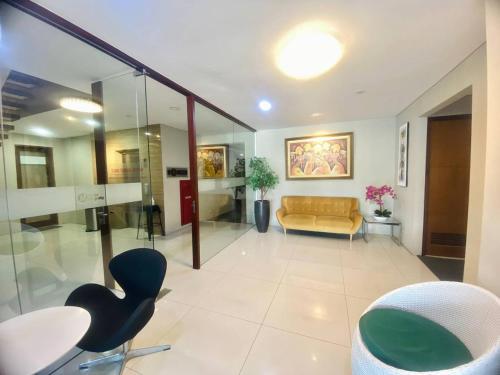 a living room with a couch and a table and chairs at Kuta Majesty Hotel in Legian