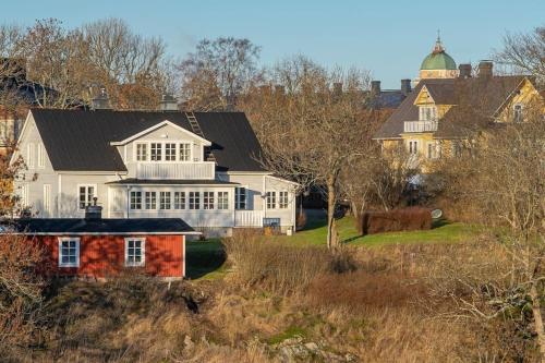 a large white house with a black roof at Seaside Cottage in Suomenlinna in Helsinki