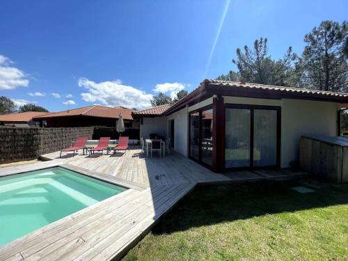 une maison avec une terrasse et une piscine dans l'établissement Maison 5 personnes avec piscine privée chauffée - Private heated pool 5 people house - Moliets-et-Maa - Landes - France, à Moliets-et-Maa
