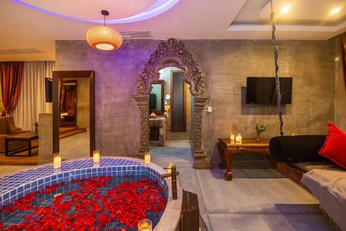 salon z dużą wanną wypełnioną czerwonymi różami w obiekcie Cambana d'Angkor Suites w Siem Reap