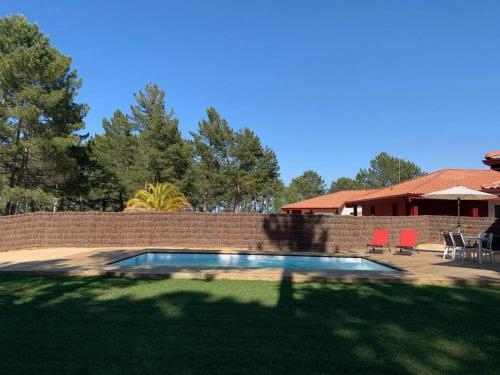 - une piscine dans une cour à côté d'un mur de briques dans l'établissement Maison 5 personnes avec piscine privée chauffée - Private heated pool 5 people house - Moliets-et-Maa - Landes - France, à Moliets-et-Maa