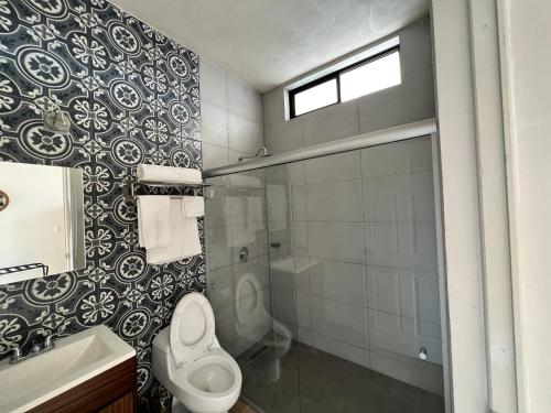 a bathroom with a toilet and a shower and a sink at Hotel Reforma in Tuxpan