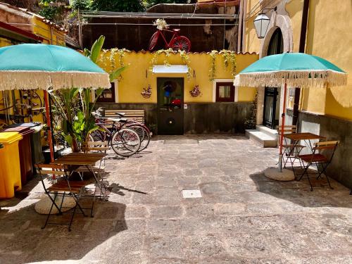 un patio con sedie e ombrelloni di fronte a un edificio di Bibike a Catania